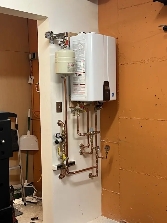 Plumbing technician inspecting water heater connections in CaÃÂ±on City